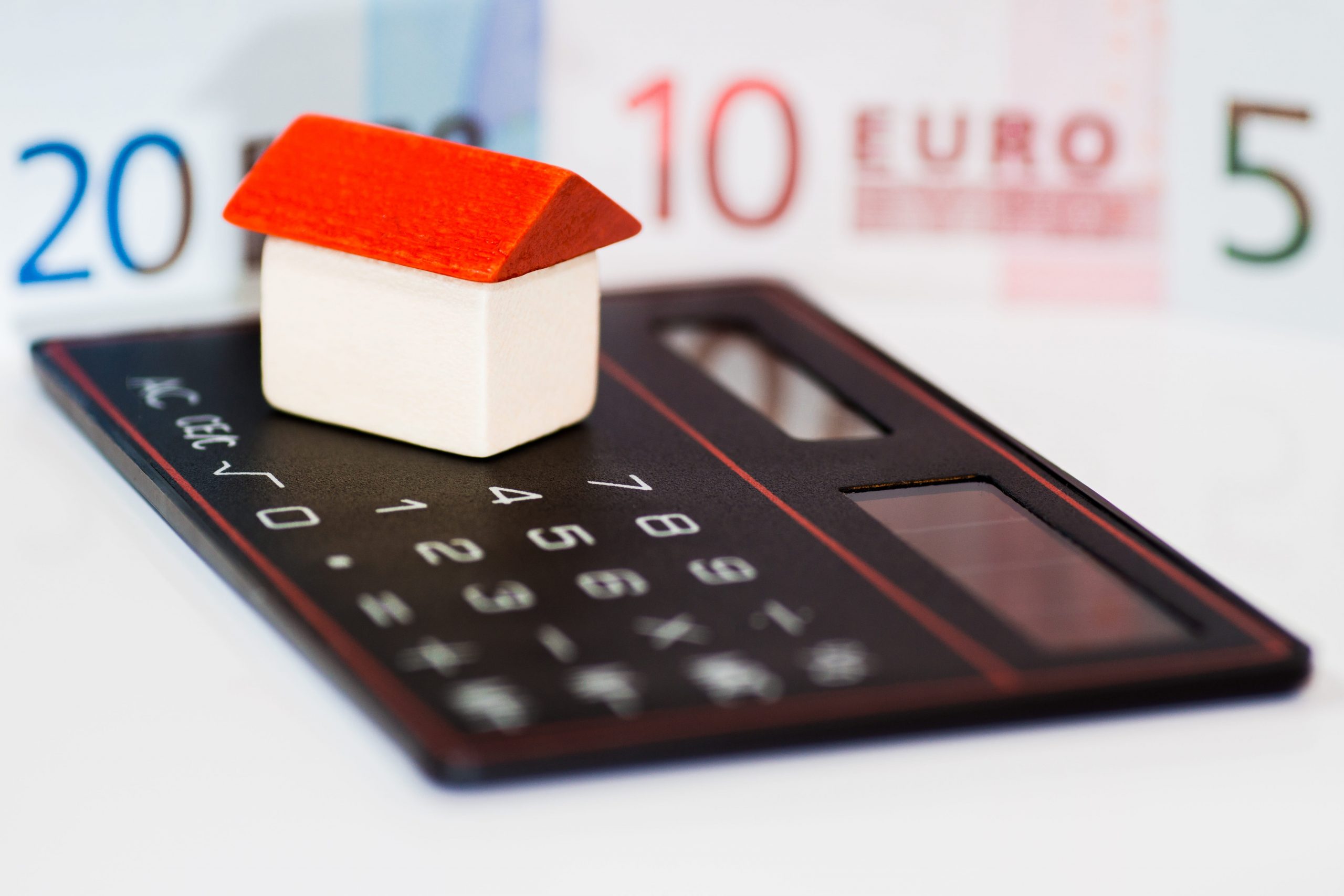 Guide to Financing for property buyers in Spain. Image showes house on calculator with euro notes in background.